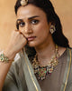 Handcrafted gold polki tukdi necklace featuring a floral pendant, pearl clusters, ruby and emerald accents, nath and fish motifs, fungar detailing, and traditional patwa threadwork.