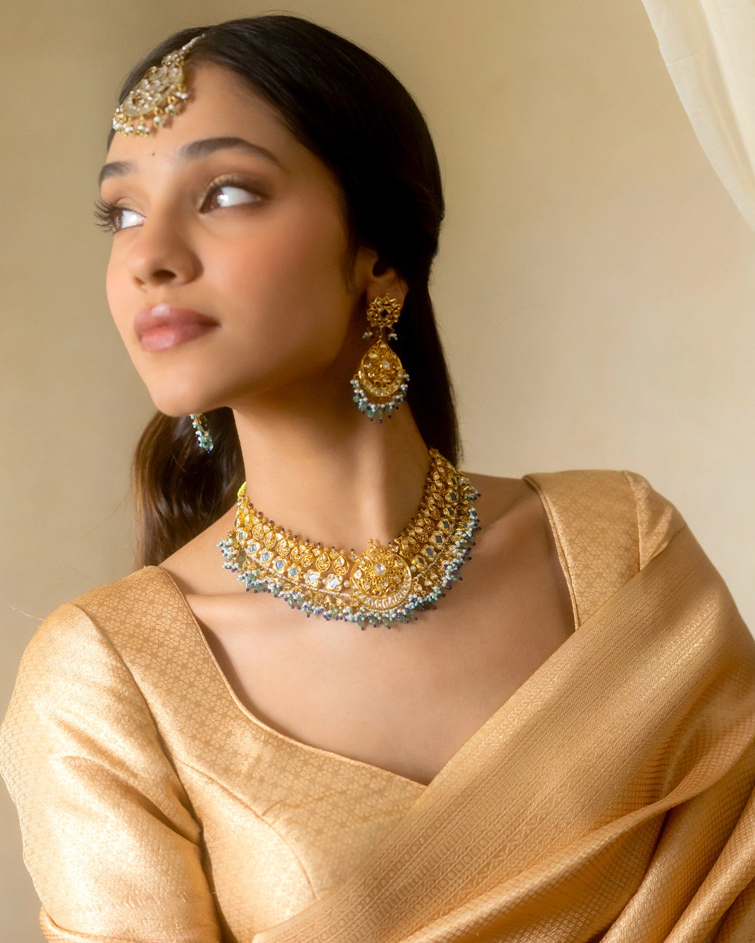 Apara polki bridal necklace with emeralds and pearls worn by a model