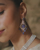 Model wearing Eza tanzanite earrings with diamonds and blue enamel