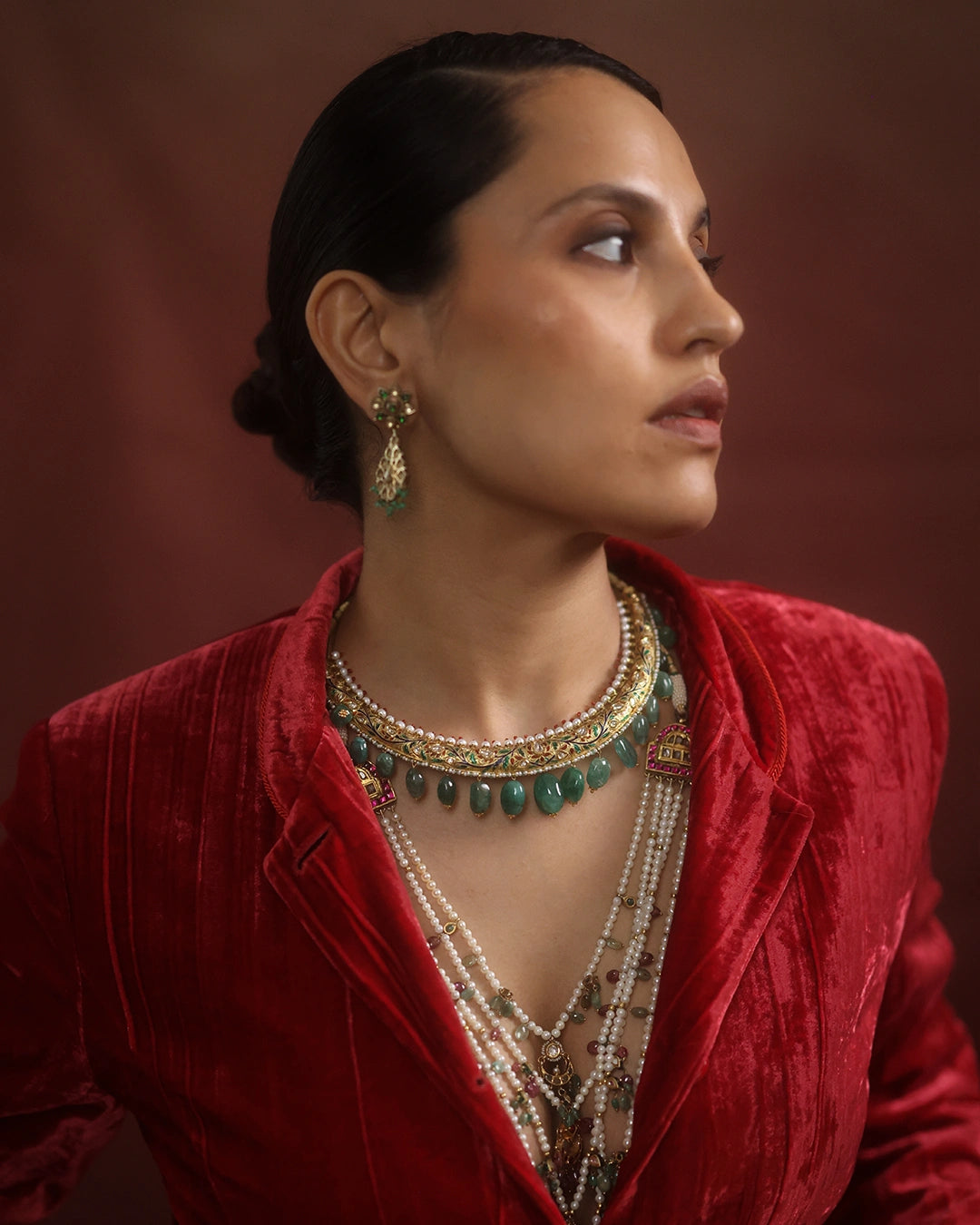 Kashi Hasli rigid gold torque necklace with hand-enamelled red and green floral vine, Polki diamond blooms, cultured pearl border, and graduating emerald drops