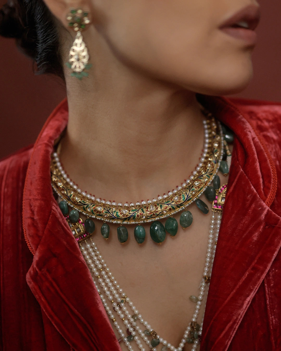 Kashi Hasli rigid gold torque necklace with hand-enamelled red and green floral vine, Polki diamond blooms, cultured pearl border, and graduating emerald drops