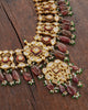 Rati gold polki necklace with uncut diamonds, wine-hued tourmaline drops, cultured pearls, green enamel accents, and intricate red meena work in a statement bridal jewellery design.