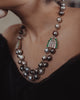 Sanea Necklace featuring multiple strands of cultured pearls with green enamel and rose-cut diamond disks, finished with diamond and emerald clasps