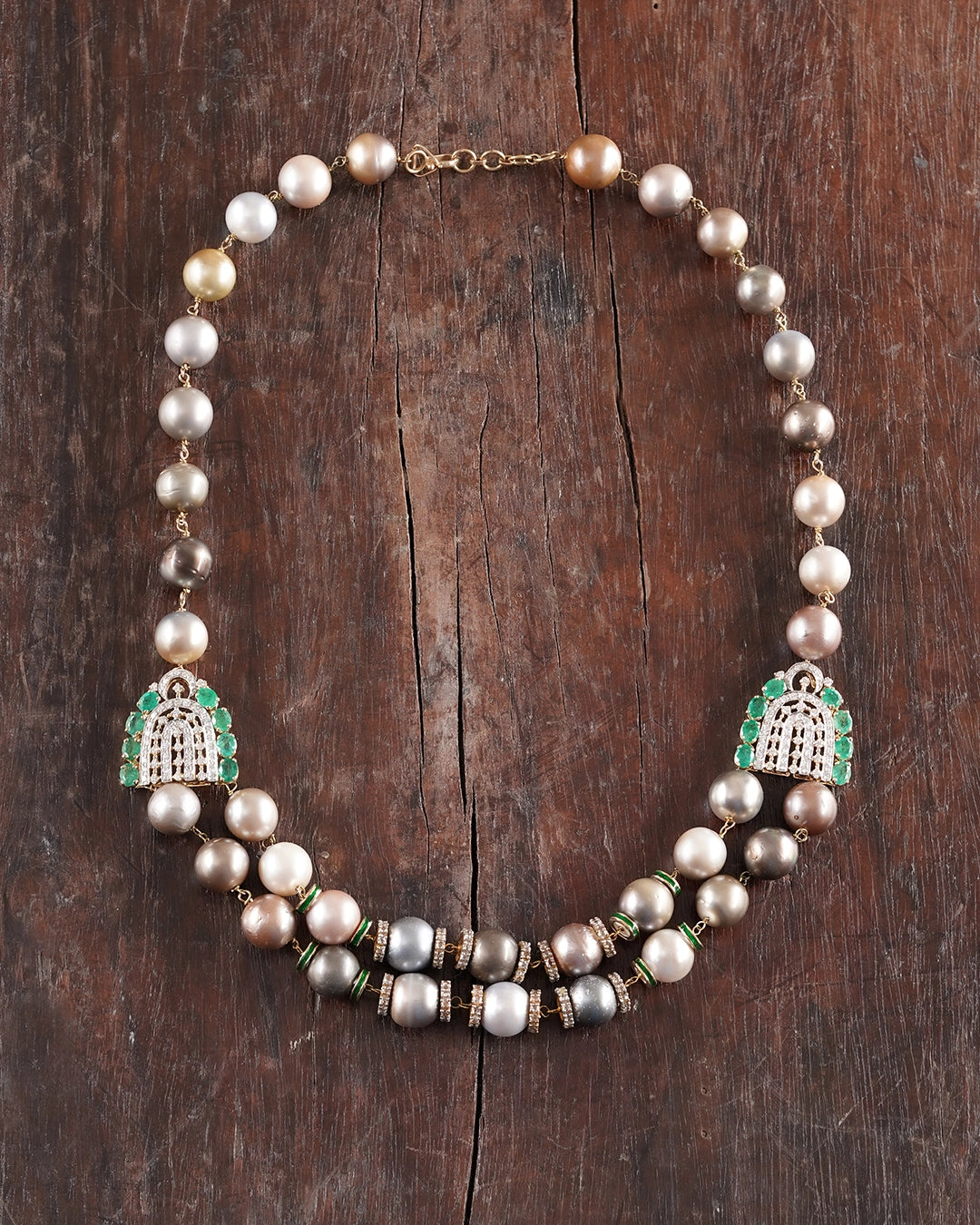 Sanea Necklace featuring multiple strands of cultured pearls with green enamel and rose-cut diamond disks, finished with diamond and emerald clasps