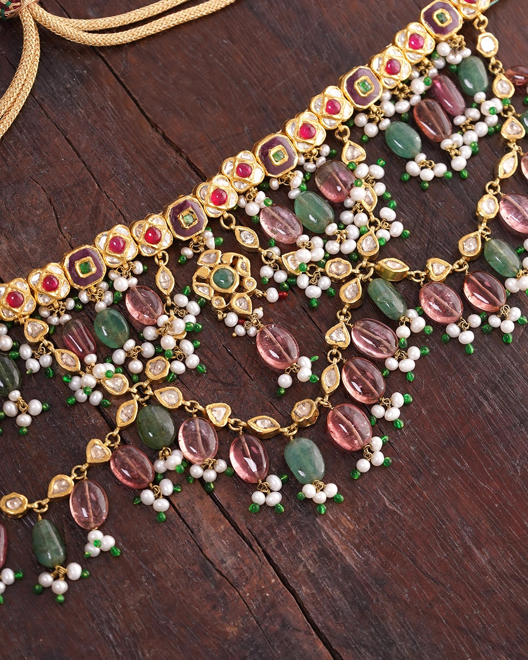Gold Kaivi Necklace with kundan-set uncut diamonds, rubies, emeralds, pearls, green enamel accents, and cascading seed pearls and tourmaline beads for women.