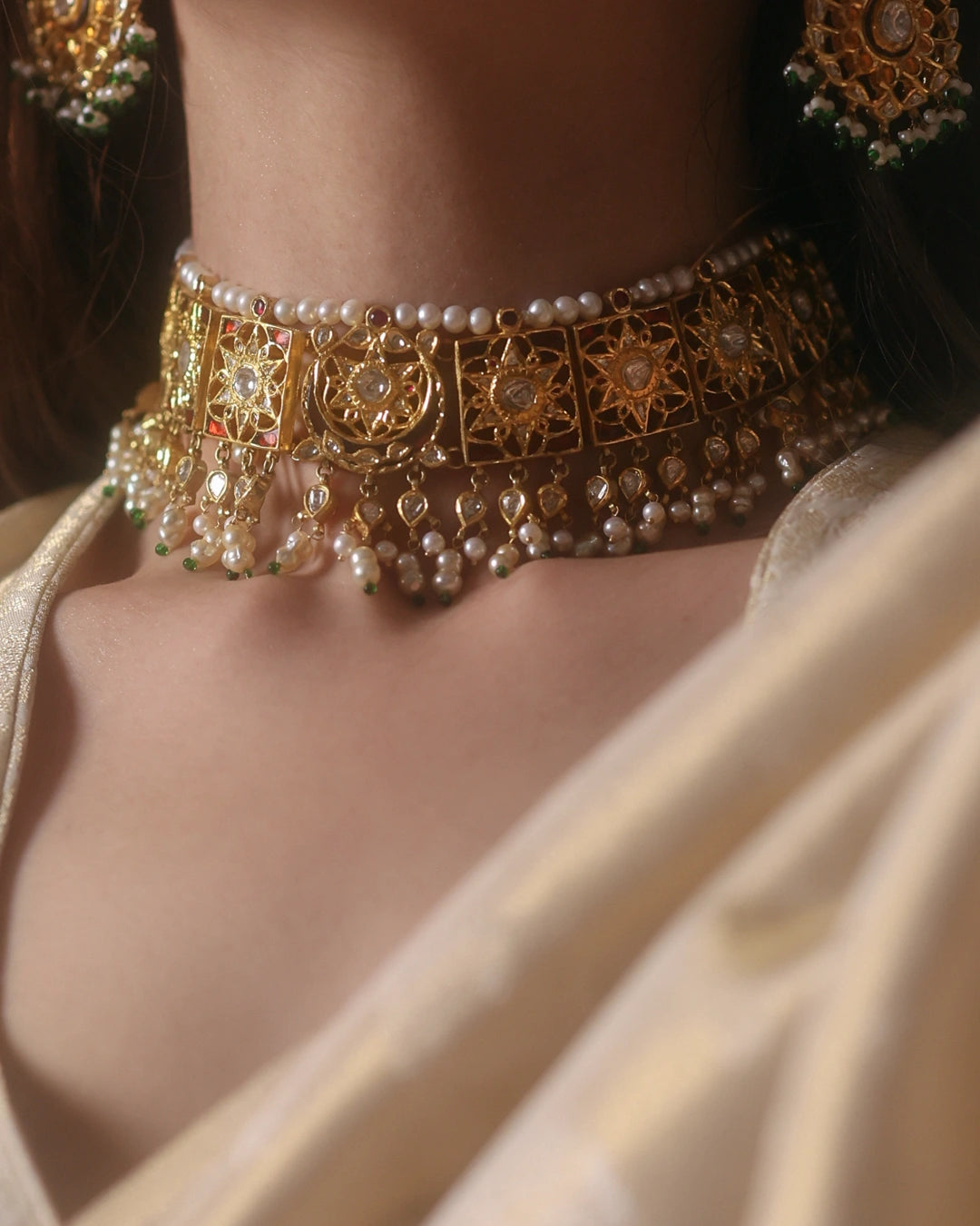 Handcrafted Indian gold bridal choker inspired by the traditional Guluband, featuring a central crescent moon (chaand) and floral (phool) motif with eight square units. Adorned with polki diamonds, kundan-set stones, pearl borders, and pearl-and-polki drop strands, this heirloom bridal necklace blends traditional craftsmanship with timeless elegance.