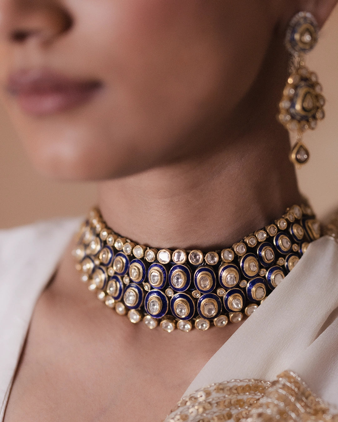 Vivir gold Polki collar necklace with graduated uncut diamonds and cobalt blue enamel borders, worn close to the throat
